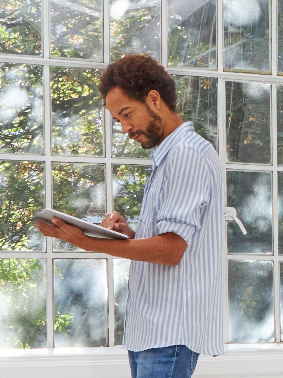 Muž stojí pred oknom v miestnosti s dobrým vetraním, ktoré zabraňuje kondenzácii a hromadeniu vlhkosti