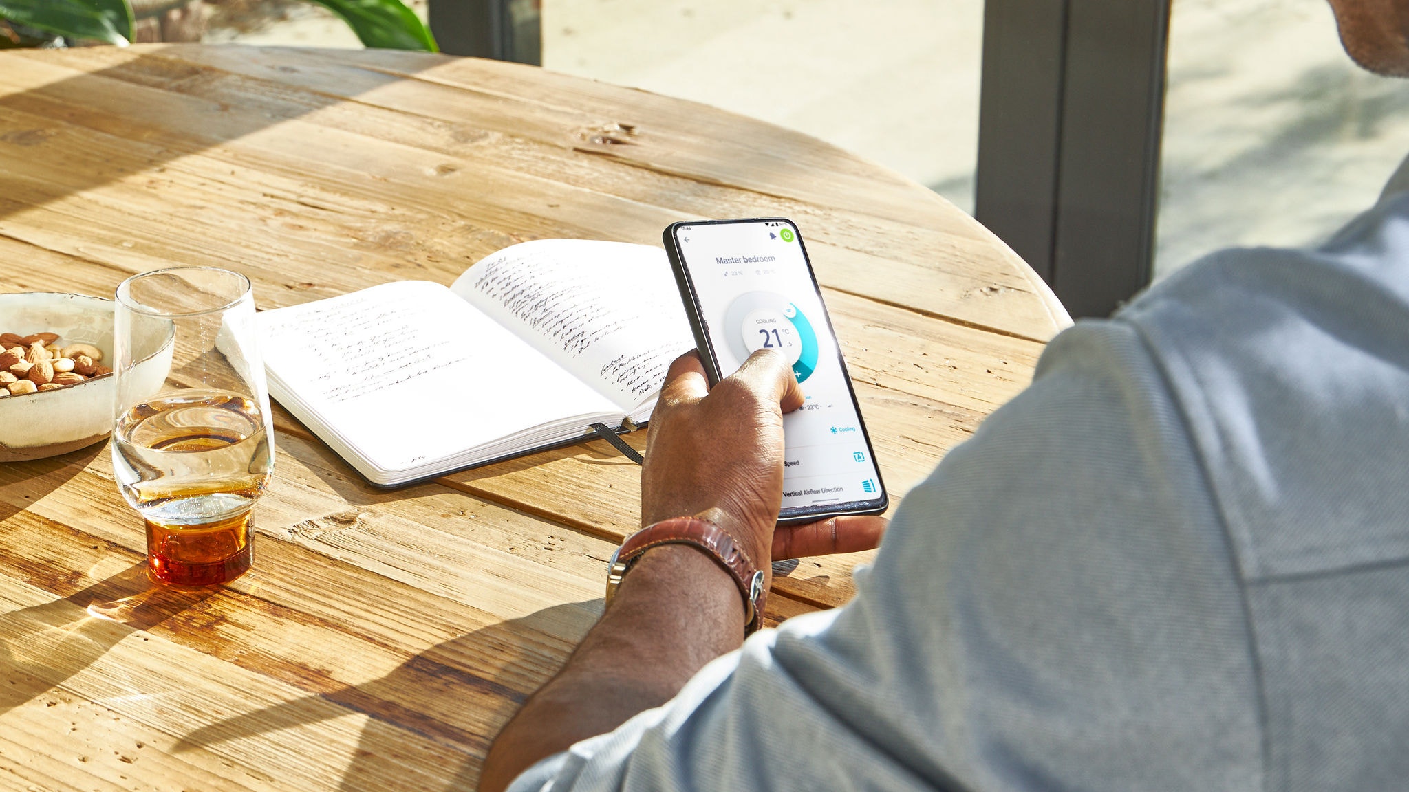 Muž ovláda teplotu vo svojej domácnosti odkiaľkoľvek pomocou apky Daikin Onecta na smartfóne