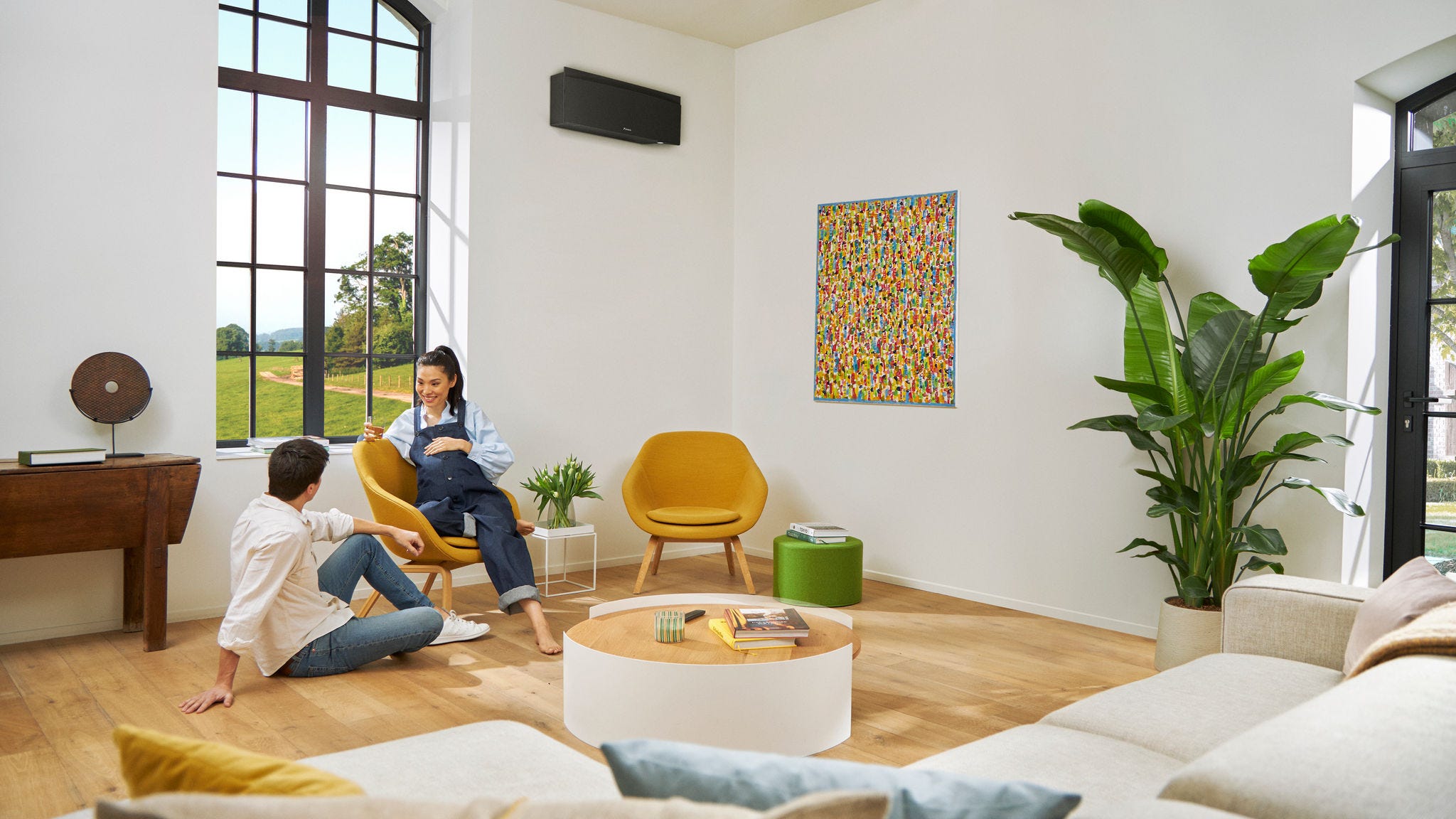 Muž a tehotná žena sediaca na stoličke sa bezstarostne rozprávajú