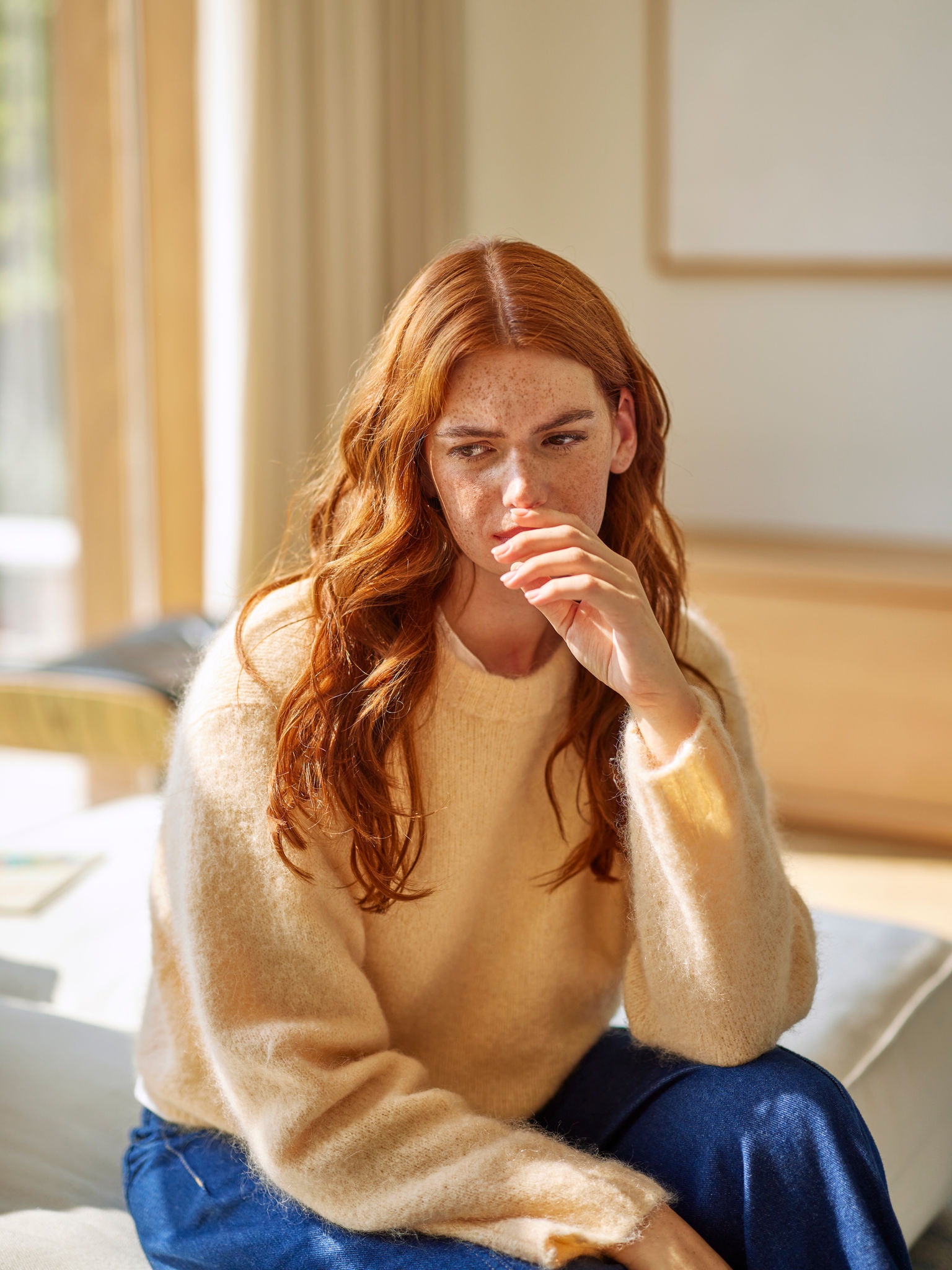 Žena reaguje na nepríjemný pach z varenia v obývacej izbe.