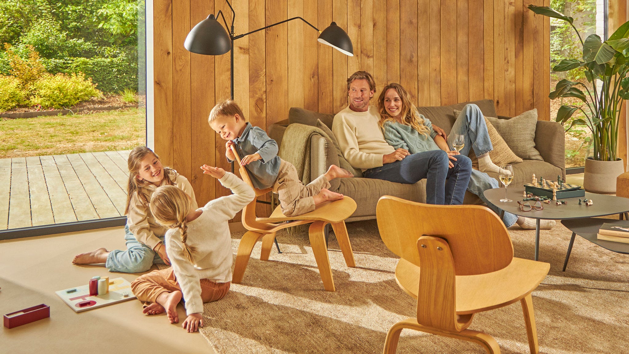 Štvorčlenná rodina sa smejúc hrá stolovú hru vo vetranej kuchyni