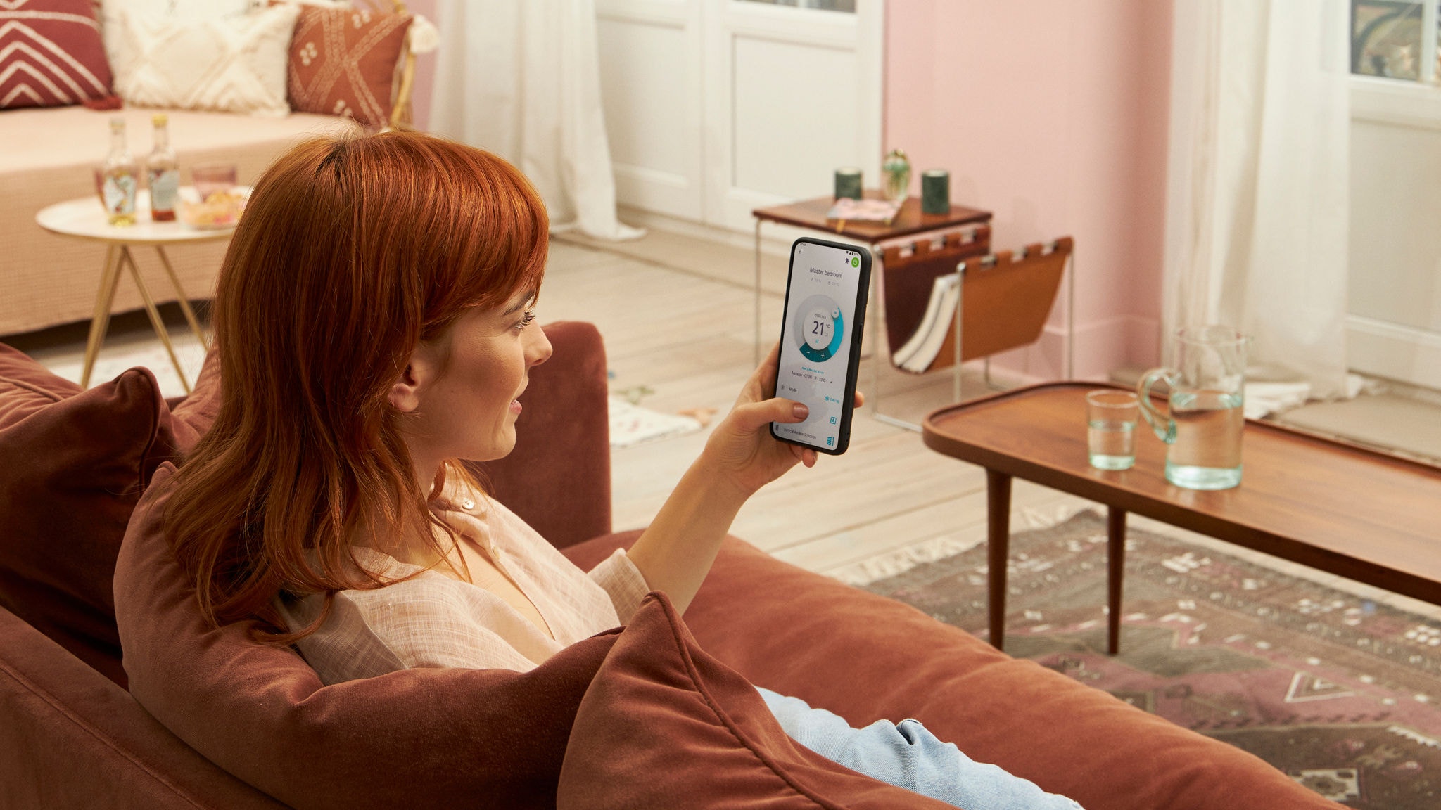 Žena sedí doma na gauči a používa aplikáciu Onecta v mobile