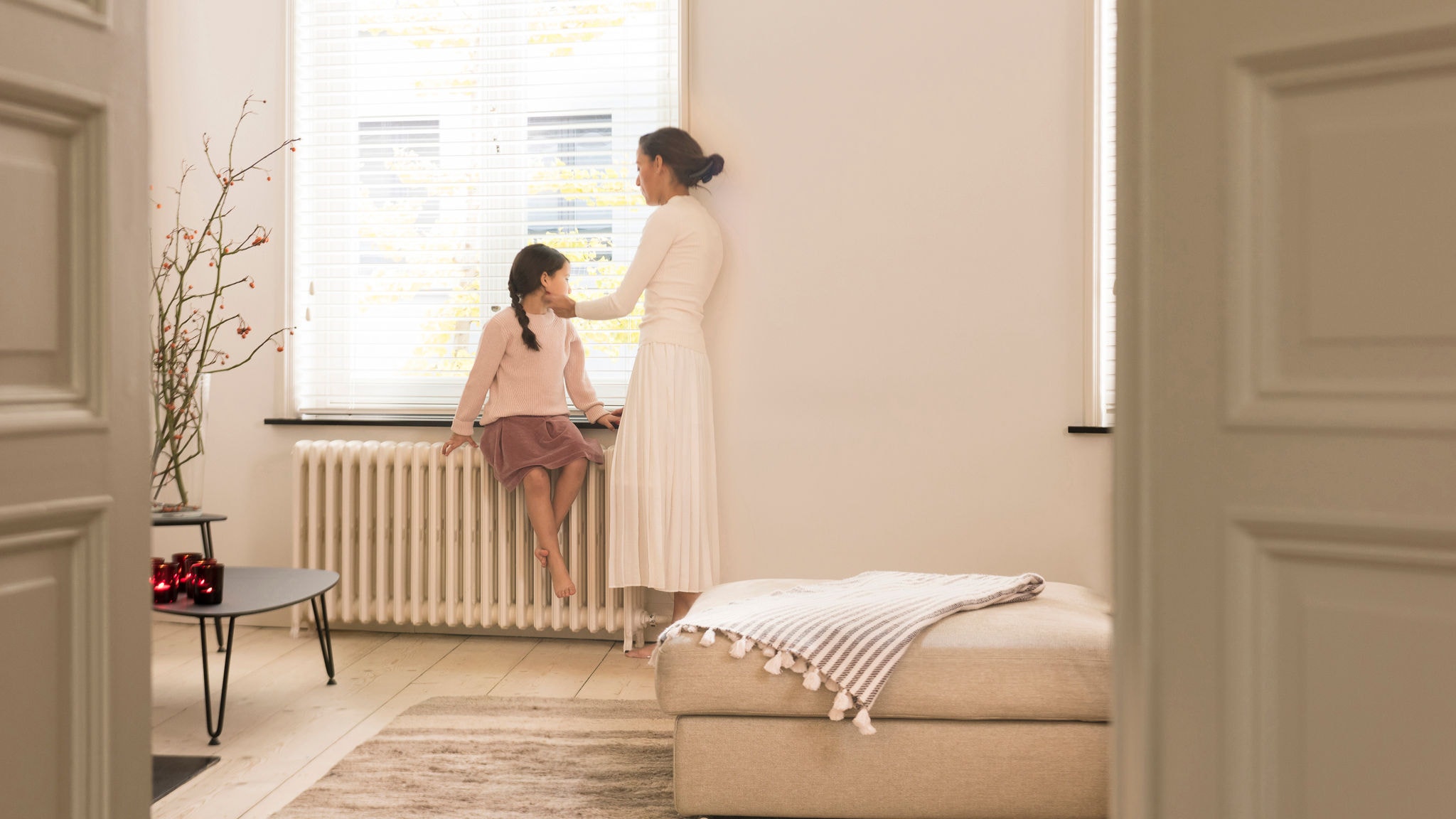 Mama s dcérou sa pri rozhovore ohrievajú pri radiátore