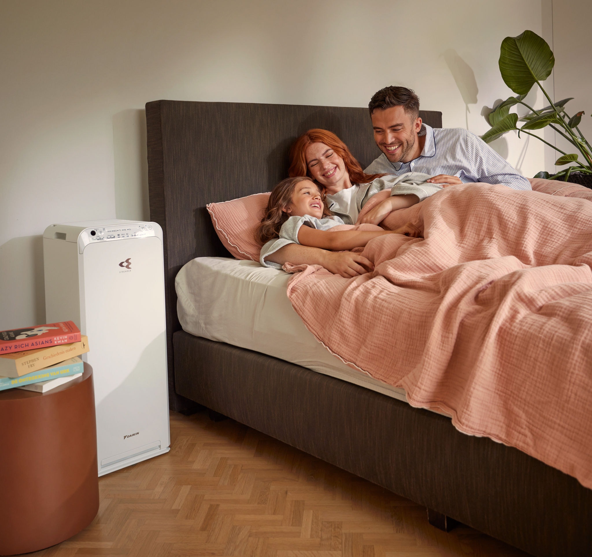 Pár s dieťaťom relaxuje v spálni a užíva si čistý vzduch vďaka čističke vzduchu
