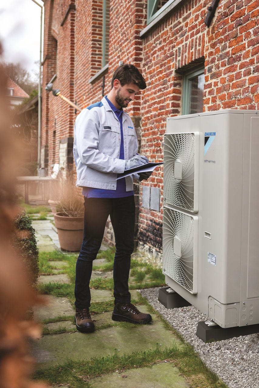 Muž inštalujúci vonkajšiu jednotku
