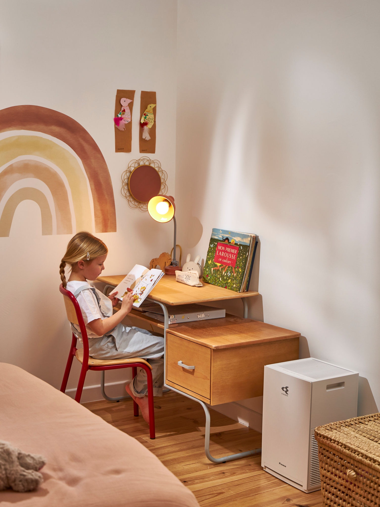 Dieťa si číta vedľa čističky vzduchu.