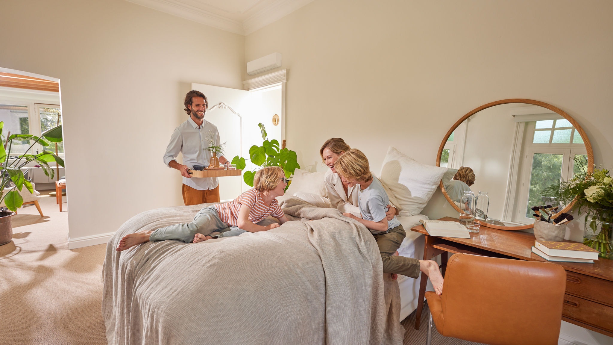 Rodina si užíva príjemné okamihy v spálni s hybridným tepelným čerpadlom namontovaným na stene