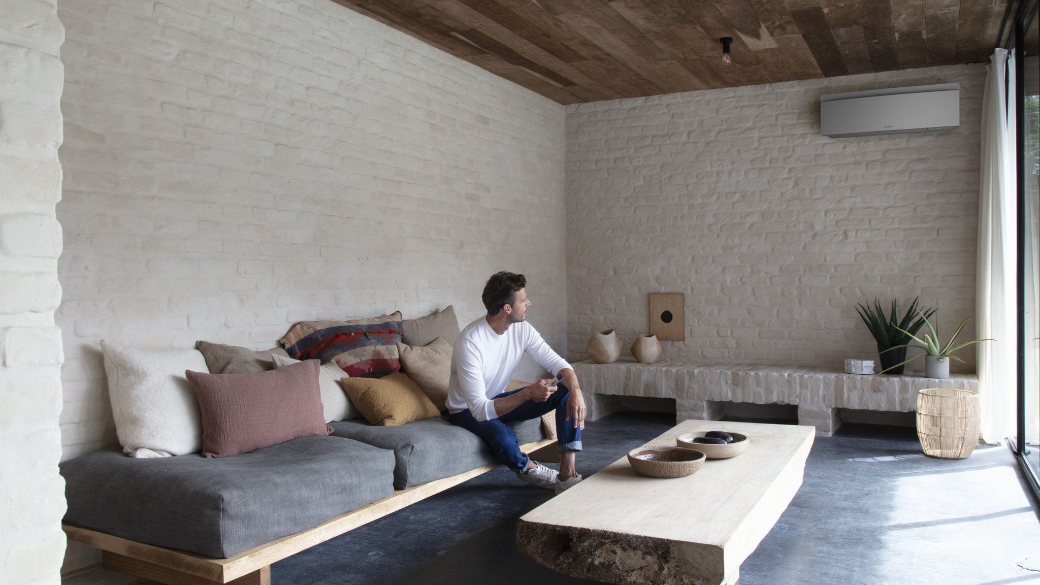 Inštalačný technik umiestňuje vnútornú jednotku Stylish na stenu